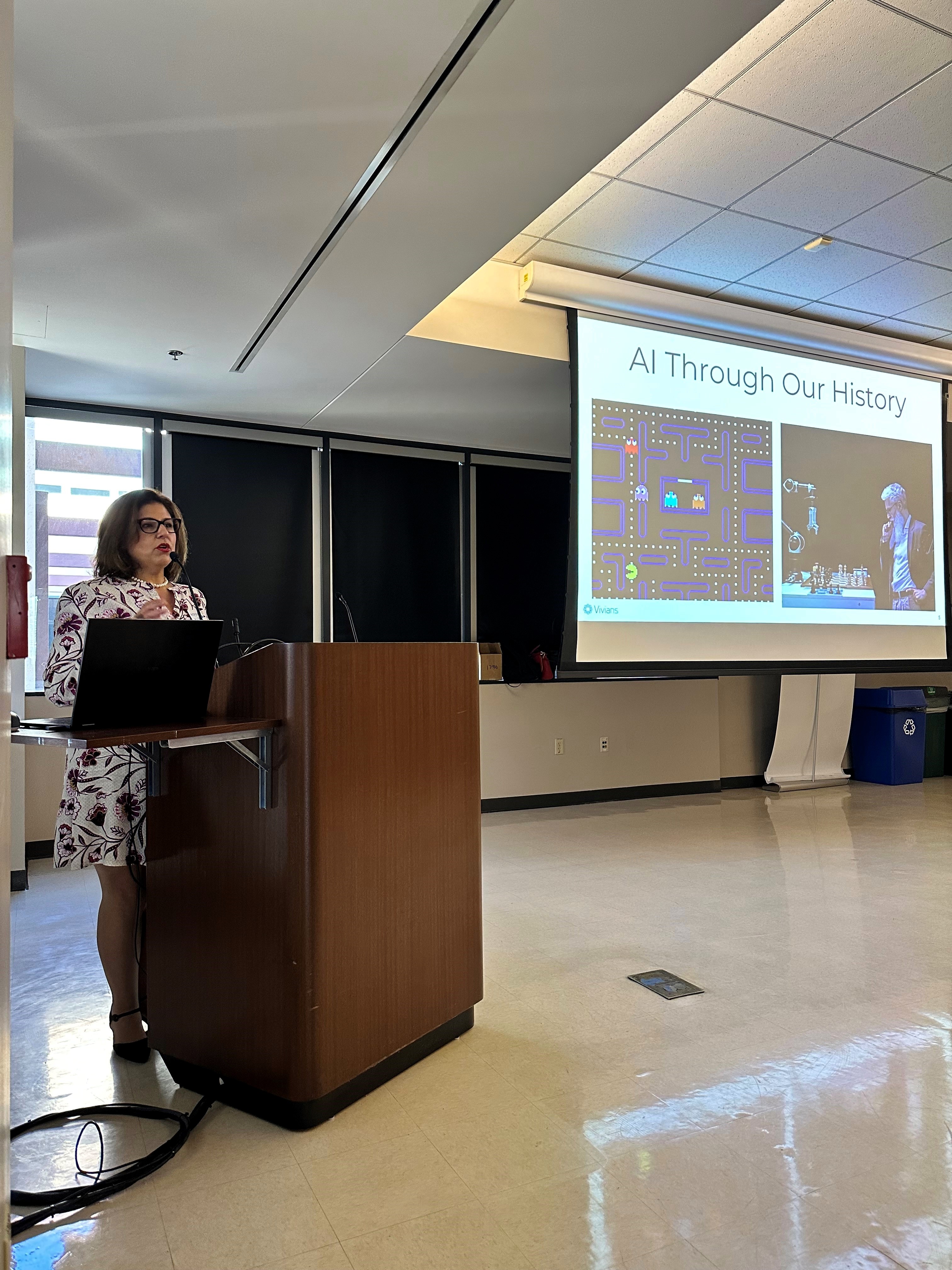 Vivian Welsh presenting the history of AI at a podium during a training session